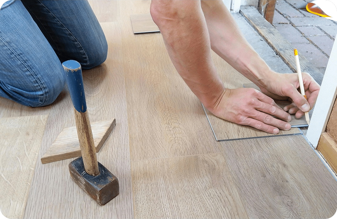 Person installing wooden floor tiles