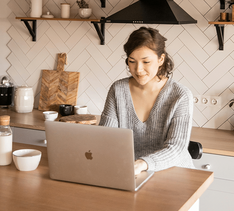 What Happens to Your Mortgage When You Sell Your House? 1 Person working on laptop in kitchen.
