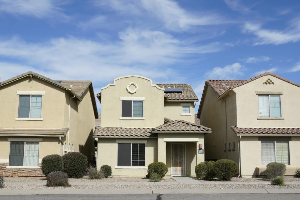 Two houses with blue sky backdrop