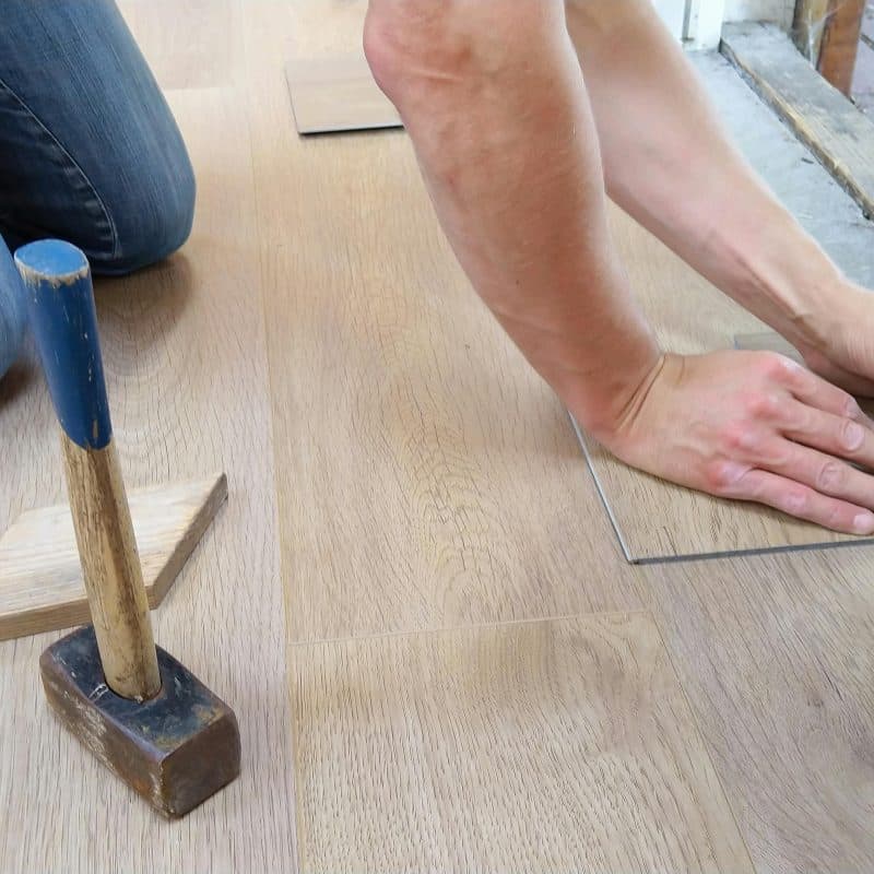 Selling a House with Unpermitted Work: What You're Risking 8 Person installing flooring with tools